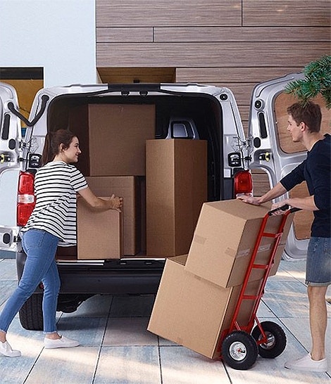 Un couple en train de mettre des cartons dans un camion de déménagement